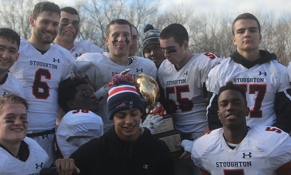 Stoughton seniors celebrate with the trophy after their 26-13 win over Canton. (Ryan Lanigan/HockomockSports.com)